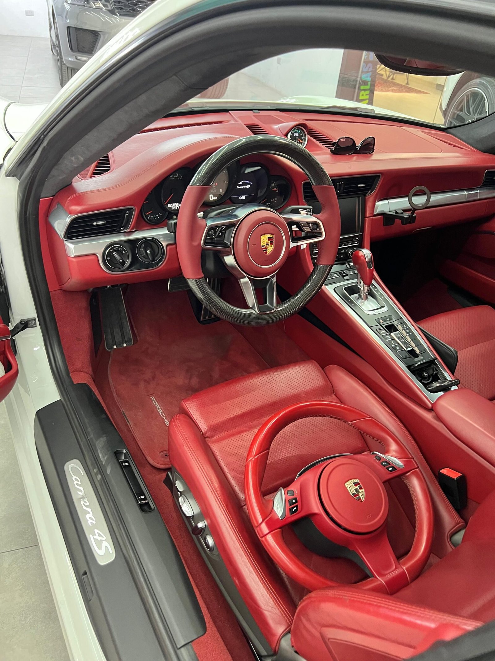Porsche interior with custom red and black steering wheel upgrade